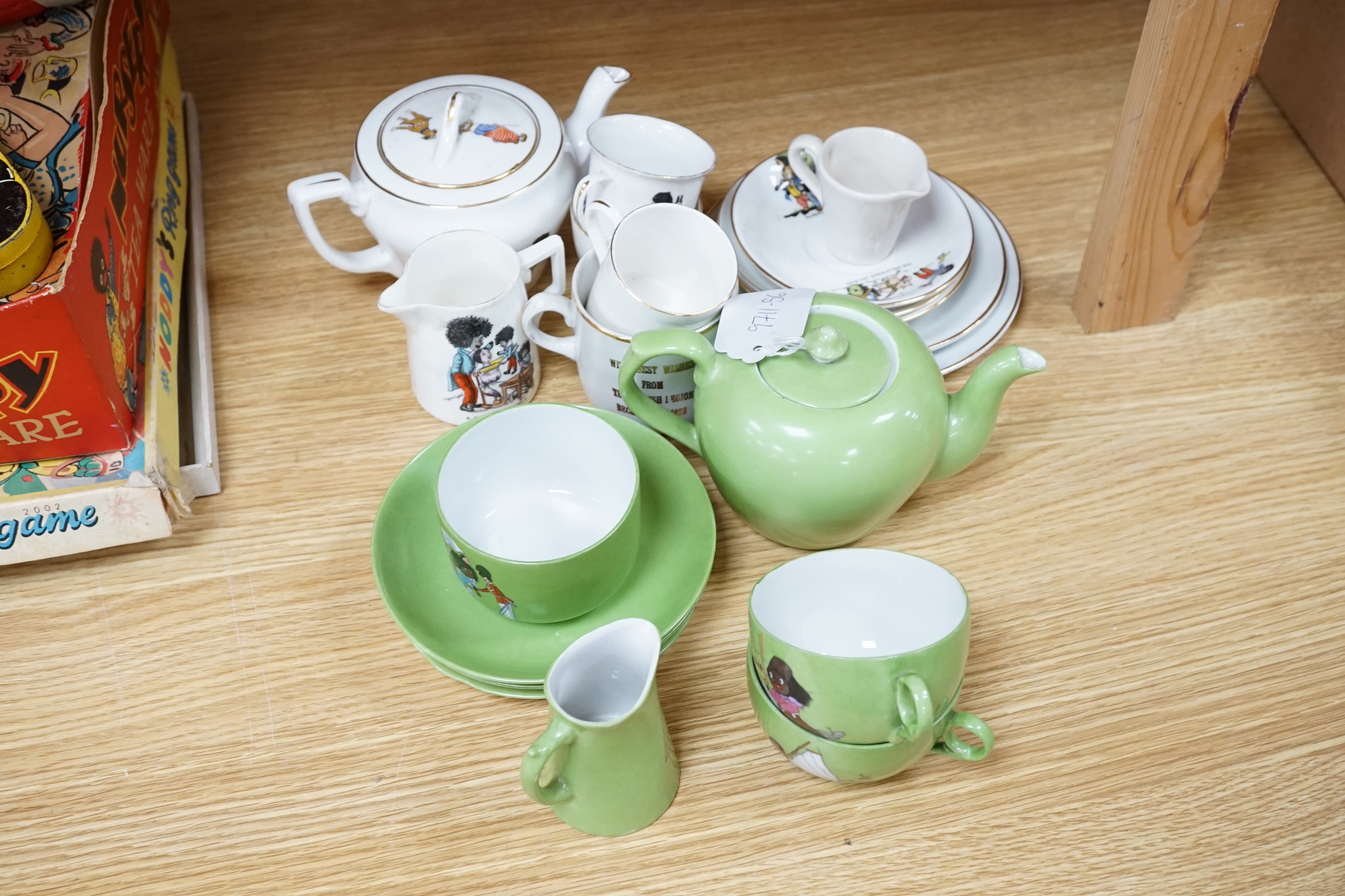 A quantity of golly china to include early green golly and a wooden doll part tea set